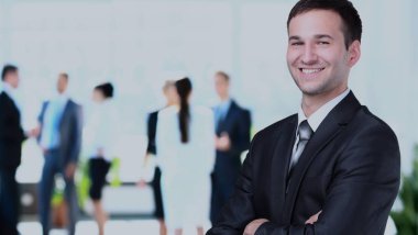 ofisinde memnuniyeti ile kameraya bakarak mutlu olgun iş adamı