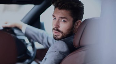 Arabanın içinde otururken kendine güvenen iş adamı