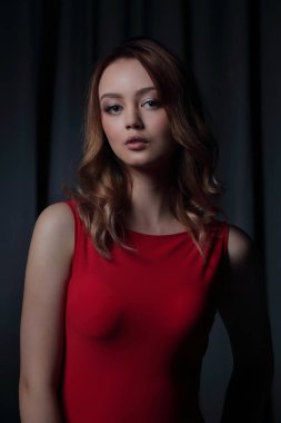 Siyah bir arka plan üzerinde poz Kırmızı elbiseli çekici esmer.