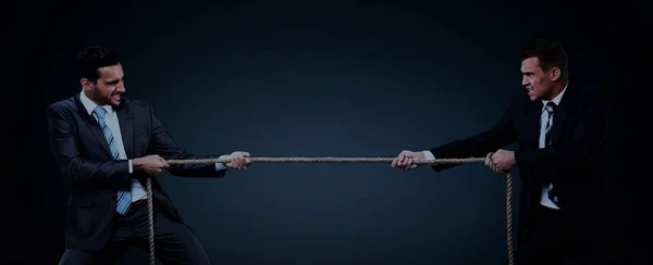 Dos hombres de negocios tirando de la cuerda en una competencia — Foto de Stock