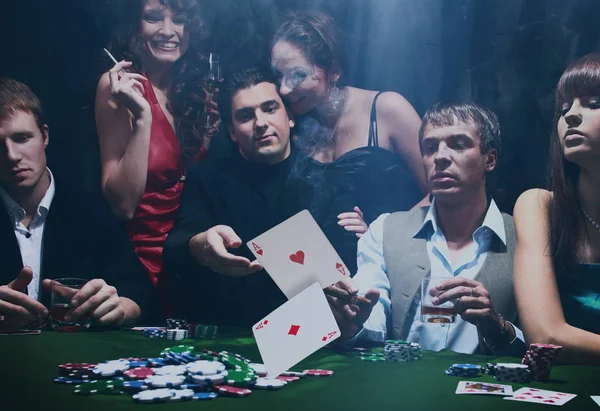 Jugadores de poker sentados alrededor de una mesa en un casino —  Fotos de Stock
