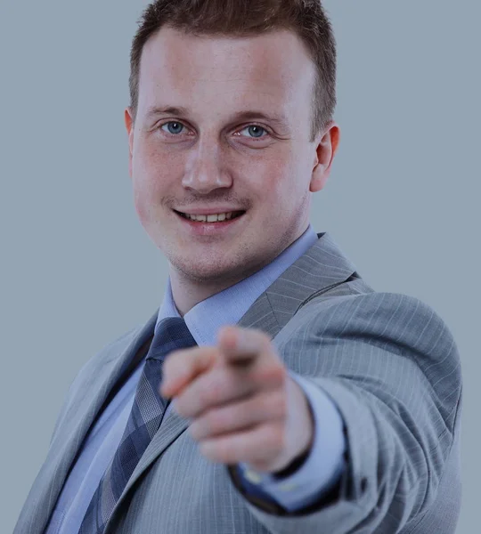 Homem de negócios sorrindo em um terno apontando com o dedo — Fotografia de Stock