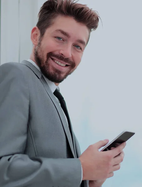 Bello uomo d'affari in un ufficio utilizzando smartphone — Foto Stock