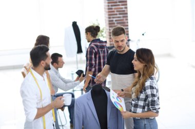 Bir grup tasarımcı erkek kıyafetlerini tartışıyor