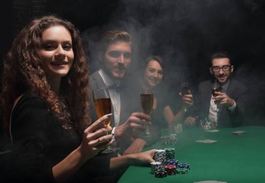 Casino oyun masasında oturan arkadaş grubu