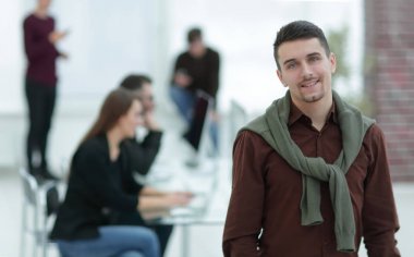 Kendine güvenen genç adam ofis arka planda.