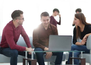 Ofiste dizüstü bilgisayar üzerinde çalışan iki adam.