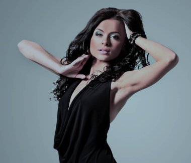 gri arka plan üzerinde poz siyah elbiseli genç esmer Bayan