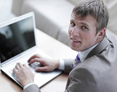 Bir dizüstü bilgisayarda çalışan takım elbiseli genç adam Üstten Görünüm