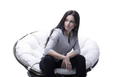 Genç kadın bir yuvarlak rahat yumuşak büyük sandalyede oturuyor.