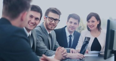 Bir grup iş ortağı ofiste fikir alışverişinde bulunuyor.