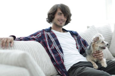 şık adam köpeğiyle kanepede oturan.