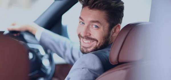 Porträt eines gut aussehenden lächelnden Geschäftsmannes am Steuer seines Autos — Stockfoto