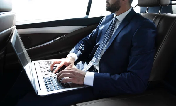 Empresario trabajando con el ordenador portátil sentado en el coche — Foto de Stock