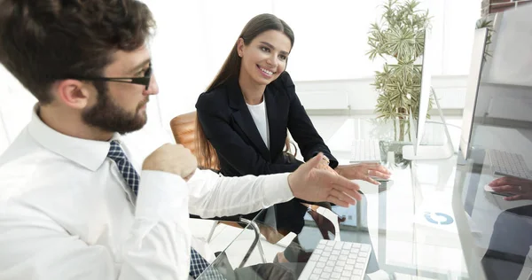 Hombre de negocios y su asistente femenino sentado en un escritorio — Foto de Stock