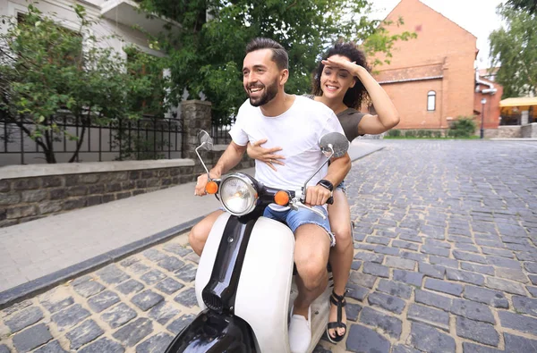 Jovem casal equitação motor scooter na cidade — Fotografia de Stock