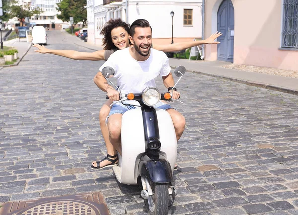 Feliz pareja joven divirtiéndose en un scooter —  Fotos de Stock