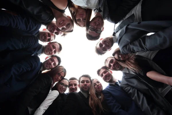 Große Business-Team bildet einen Kreis und blickt in die Kamera — Stockfoto