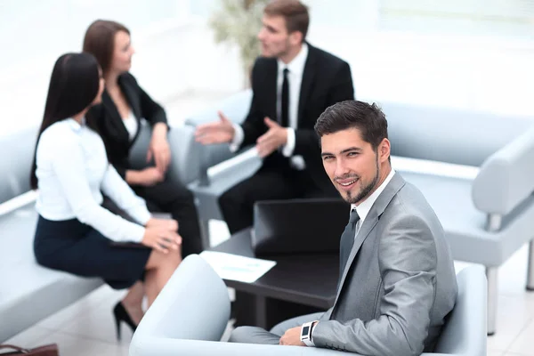 Geschäftsmann sitzt in einem Büro auf dem Hintergrund des Business-Teams. — Stockfoto
