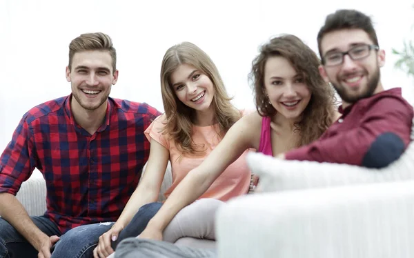 Skupina veselých přátel sedí na pohovce — Stock fotografie