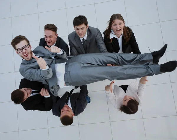 Obchodní tým šťastně hodí své kolegy ve vzduchu celebrita — Stock fotografie