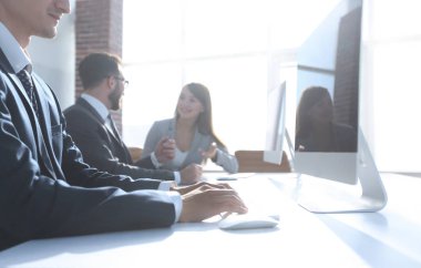 Ofis çalışanları çalışma masasında oturuyorlar.