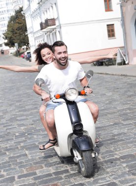 mutlu genç bir çift bir scooter üzerinde eğleniyor
