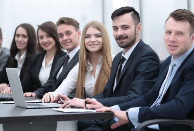 İş ekibi konferans odasındaki masada oturuyor.