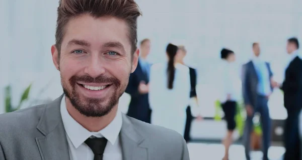 Hombre de negocios guapo en una oficina con fondo borroso — Foto de Stock