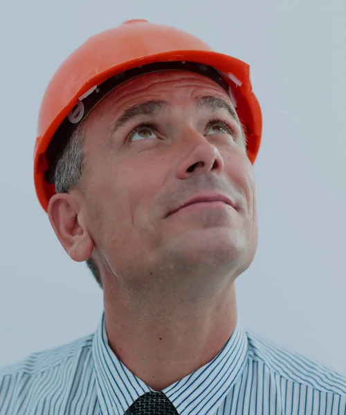 Портрет инженера в оранжевом шлеме, смотрящего вверх — стоковое фото