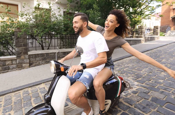 Elegante jovem casal senta-se uma scooter na rua . — Fotografia de Stock