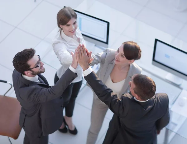 Tim bisnis yang sukses memberikan satu sama lain tos, berdiri di kantor — Stok Foto