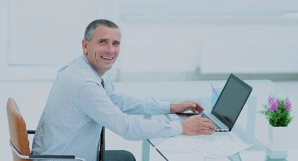 Uomo d'affari sorridente di successo che lavora sul computer portatile alla scrivania in offi — Foto Stock