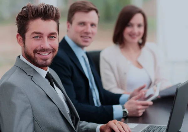 Elegante medewerkers camera kijken tijdens de bijeenkomst in office — Stockfoto