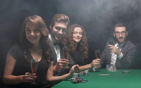 Joueurs de poker avec un verre de vin, assis à la table Photo De Stock