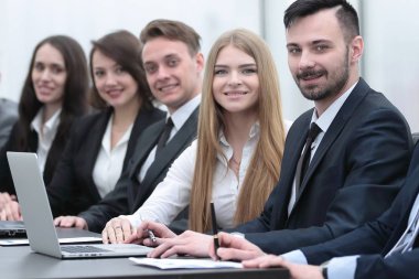 İş ekibi konferans odasındaki masada oturuyor.