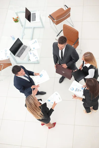 View from the top.business team discussing marketing charts, standing in the office . — стоковое фото