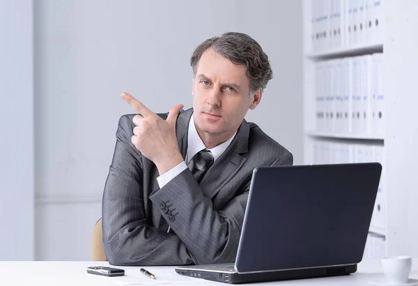 Primer plano. hombre de negocios confiado apuntando al espacio de copia . — Foto de Stock