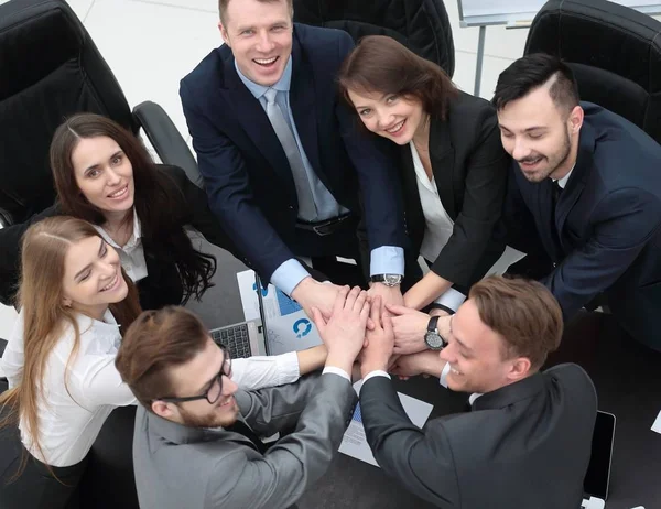 Equipe de negócios com as mãos apertadas juntas na mesa — Fotografia de Stock