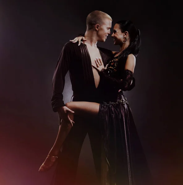 Ballando giovane coppia su uno sfondo nero . — Foto Stock
