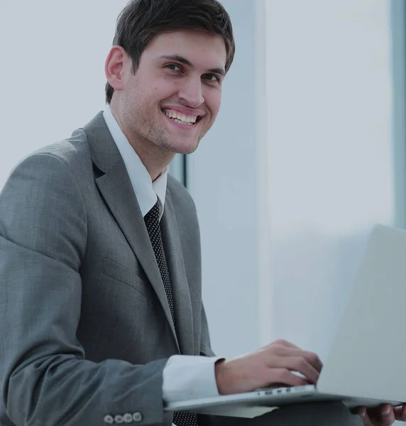 Modern ofiste bilgisayarla çalışan mutlu genç bir iş adamı. — Stok fotoğraf