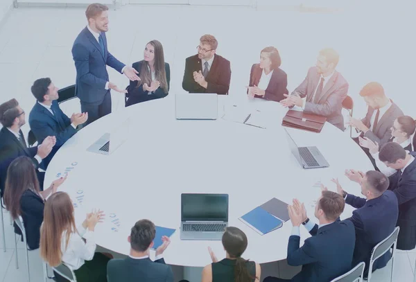 Equipe de negócios bem sucedida sentado em uma mesa redonda e aplaude t — Fotografia de Stock