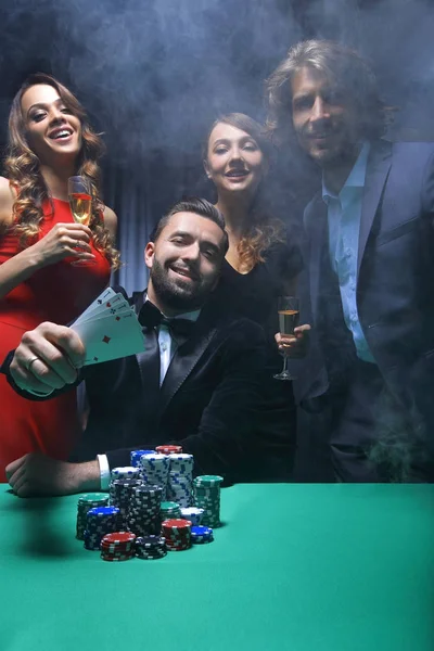 Portret van een groep mensen met drankjes spelen van poker in de casino — Stockfoto