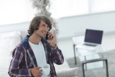 güzel bir fincan adamla bir dizüstü bilgisayar önünde oturur.