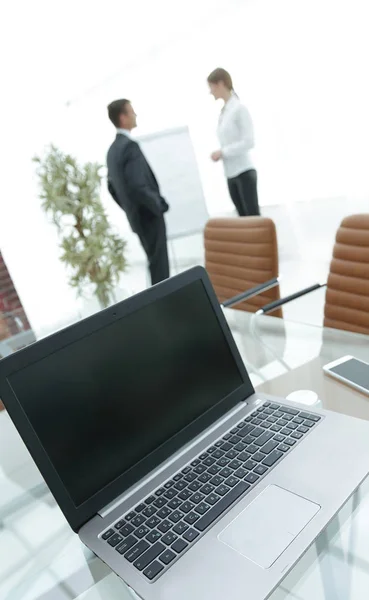 Laptop e um smartphone na área de trabalho na sala de conferências . — Fotografia de Stock