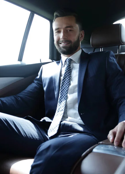 Uomo d'affari seduto sul sedile posteriore di una macchina — Foto Stock