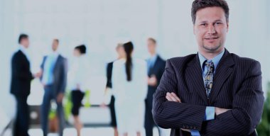 ofisinde memnuniyeti ile kameraya bakarak mutlu olgun iş adamı