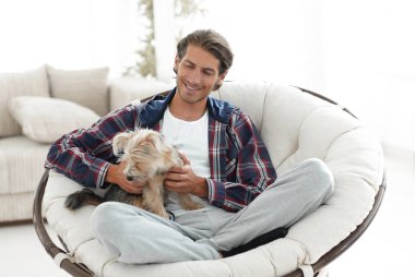 yakışıklı olan büyük bir koltukta oturan bir köpekle.