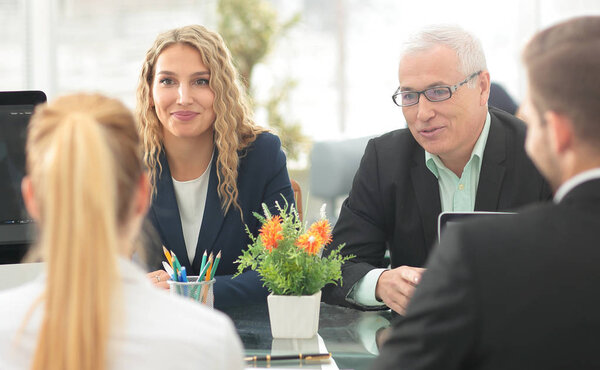 Группа уверенных деловых партнеров обсуждает бумагу на встрече