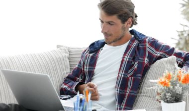 şaşırmış genç adam evden dizüstü bilgisayar ile çalışma.